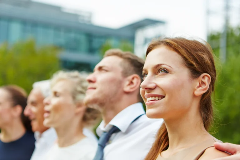 grupa ludzi z uśmiechem patrzy przed siebie