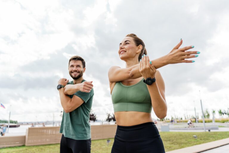 dwójka ludzi rozciąga się przed bieganiem na świeżym powietrzu