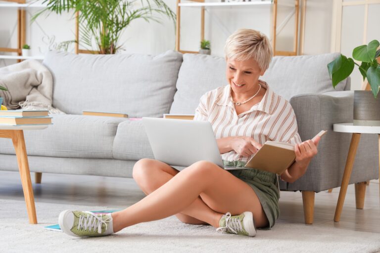 kobieta w domu uczy się czegoś z książką i laptopem